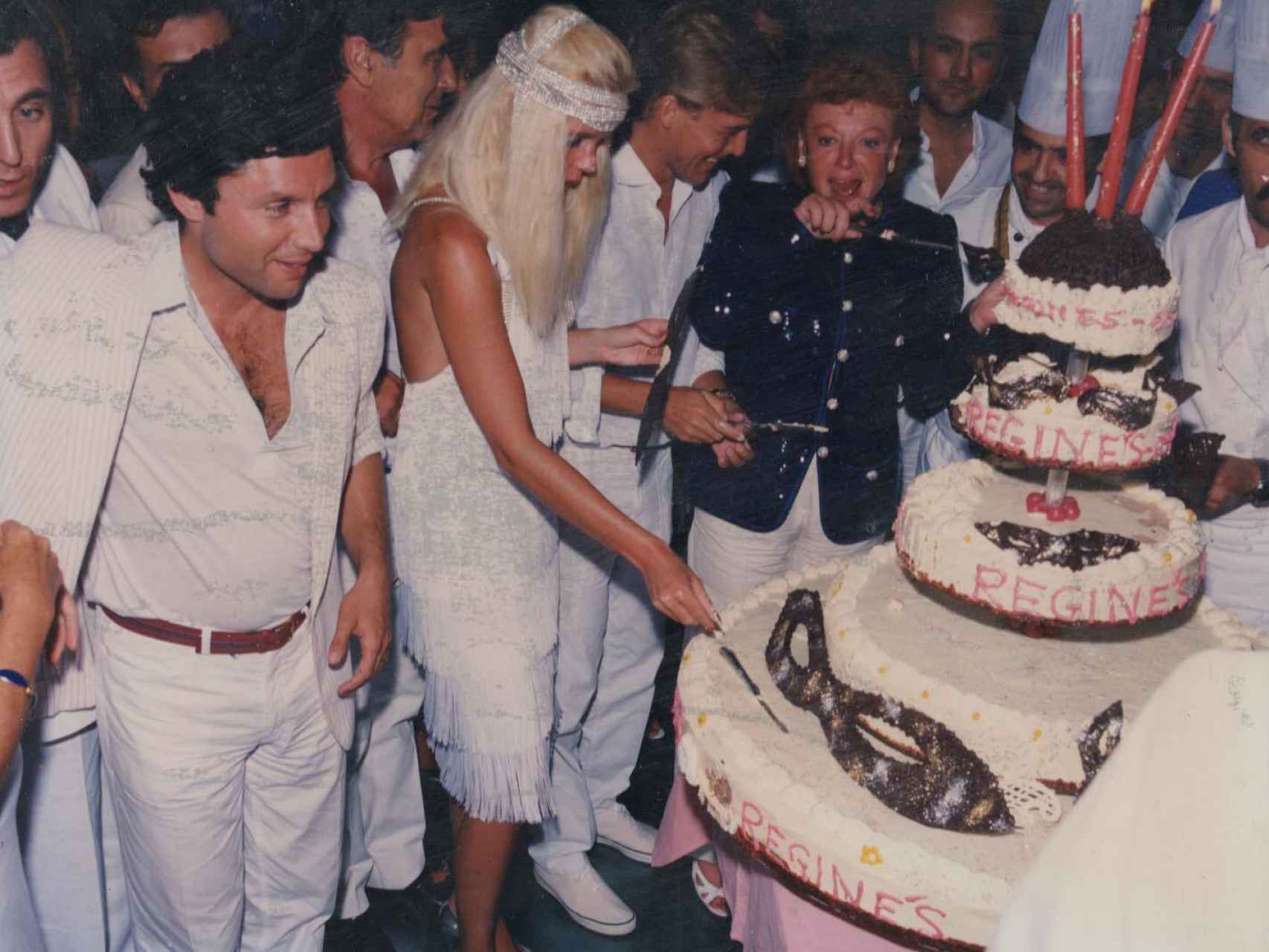 Régine partiendo una enorme tarta con su nombre en su local de Marbella.