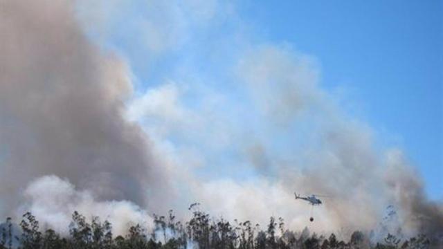 Helicóptero actuando en un incendio en un monte gallego.