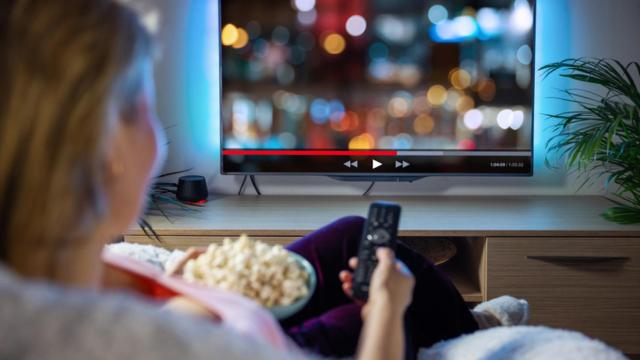 Una mujer ve la televisión.