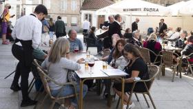 Un grupo de turistas consulta una carta en la terraza de un bar en Santiago de Compostela.