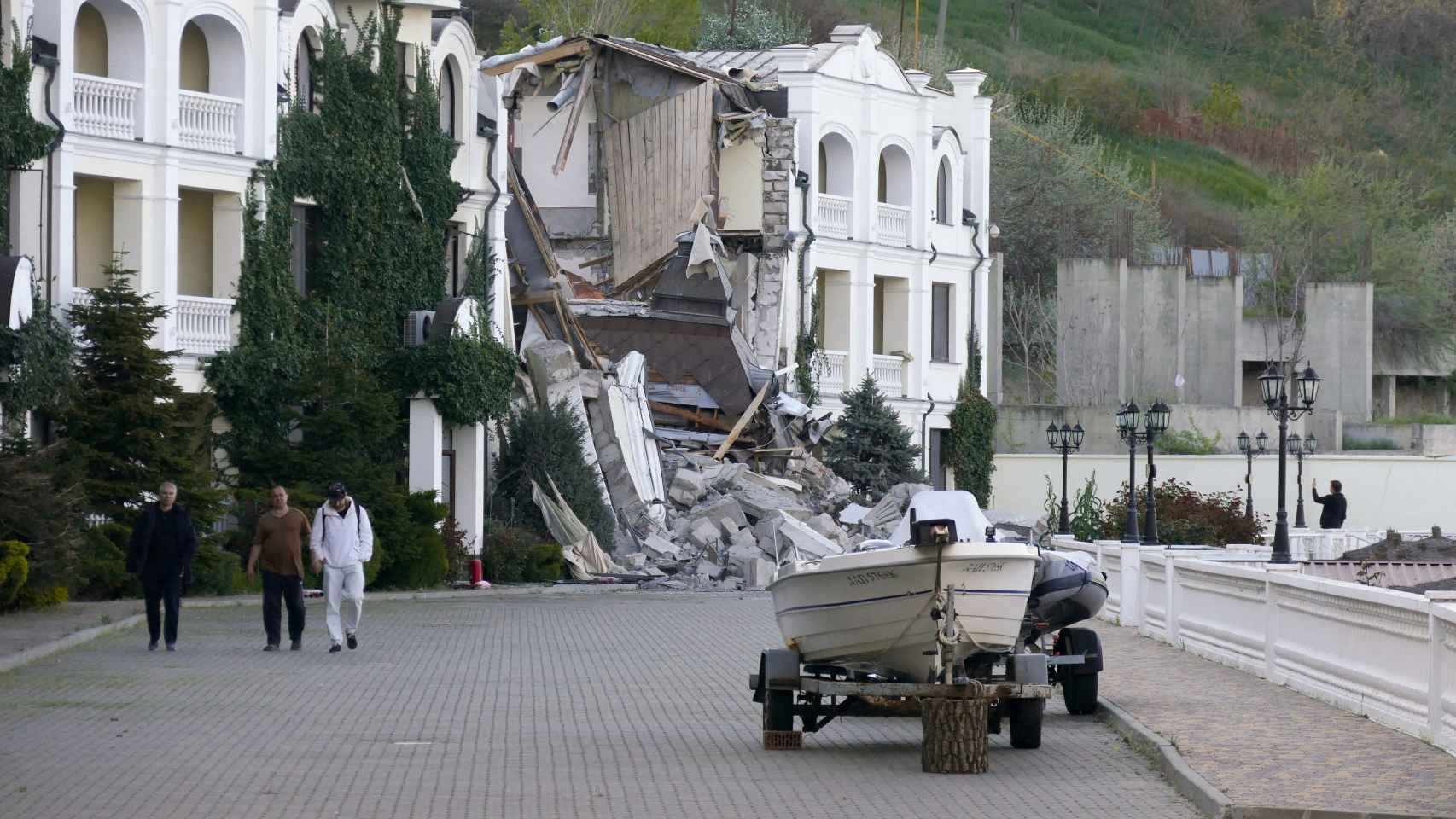 Varios civiles pasean por delante de un edificio atacado por los rusos en Zaporiyia