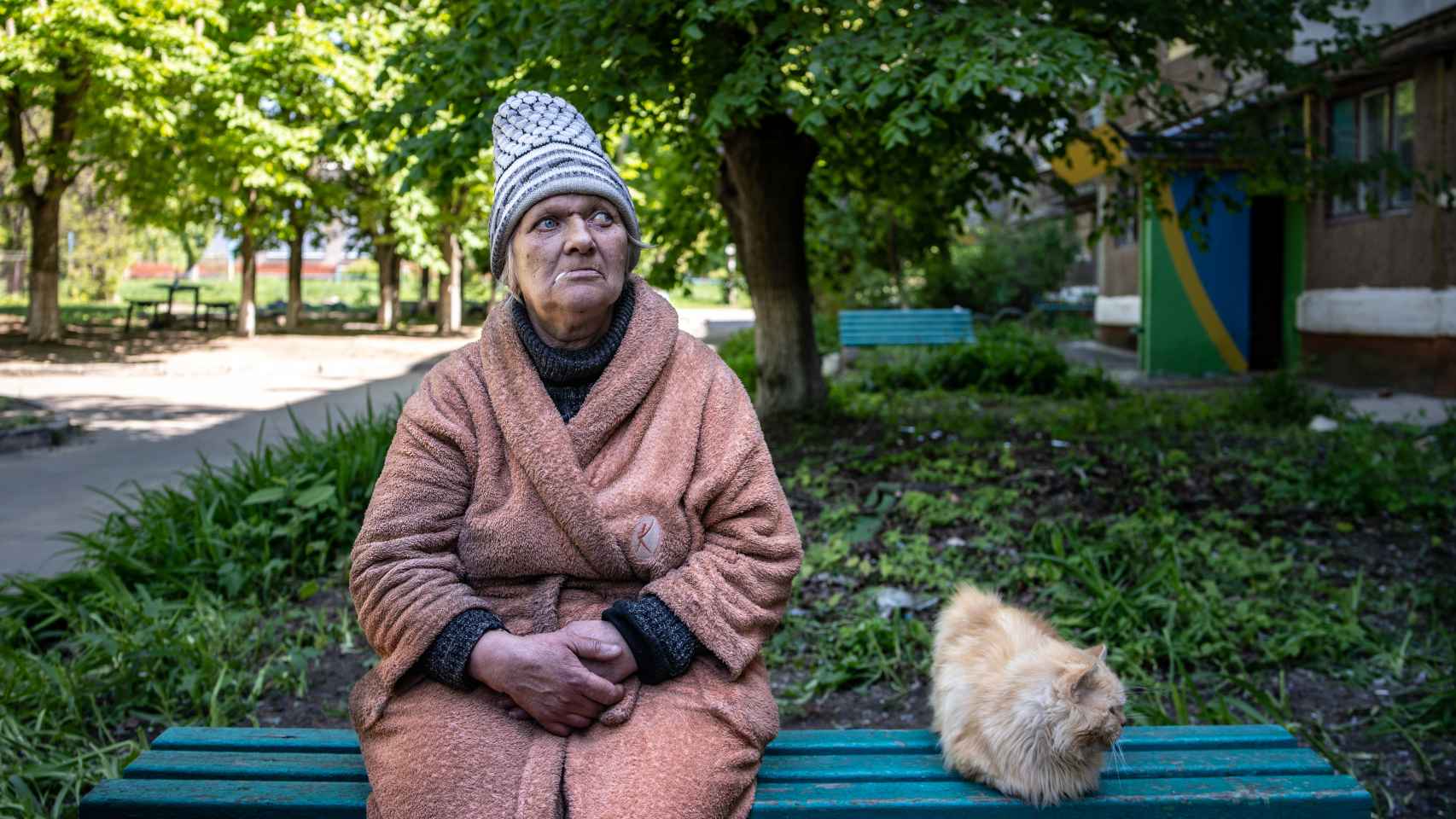 Natasha Mikhailova en las inmediaciones de su casa junto a un gato callejero.