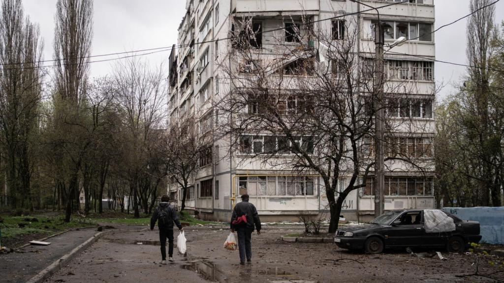 Svyatoslav y Yura caminan con bolsas de comida y velas para repartir en las partes más castigadas del barrio.