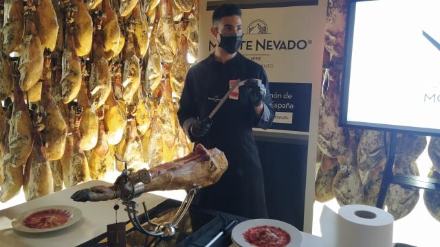 Daniel Olmos, quinta generación de la familia, cortando jamón durante la inauguración del Campus del Jamón.