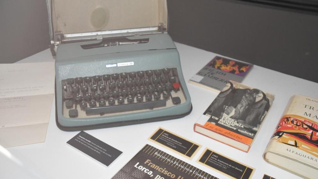 La exposición reúne diversos manuscritos y objetos cotidianos relacionados con la escritura de Umbral, como la Olivetti Lettera 32 con la que escribía.