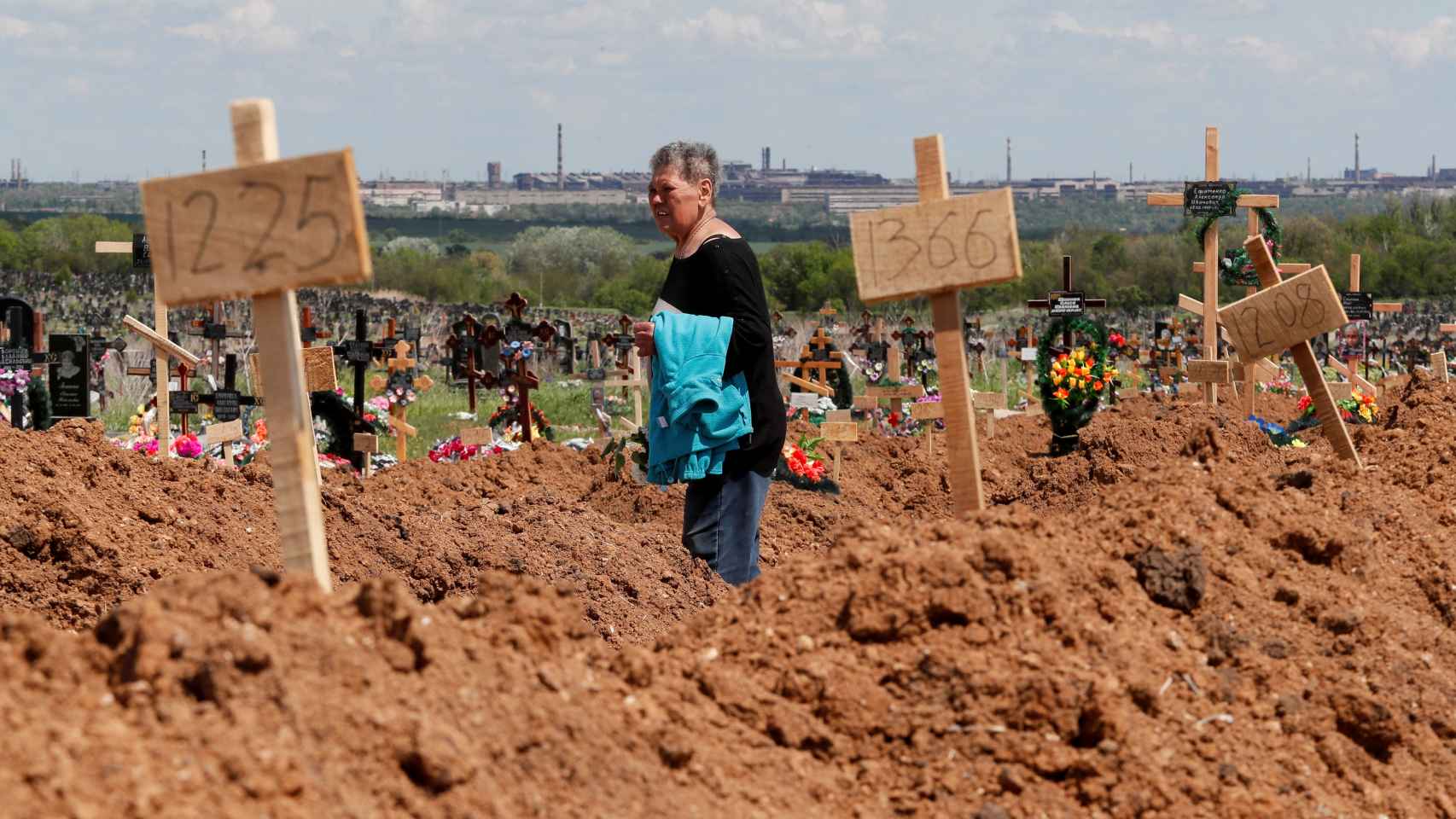 Una mujer camina por un cementerio situado en Mariúpol este domingo 15 de mayo