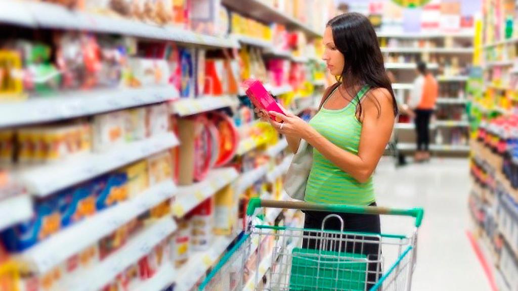 Una mujer comprando productos de higiene íntima femenina como las compresas.