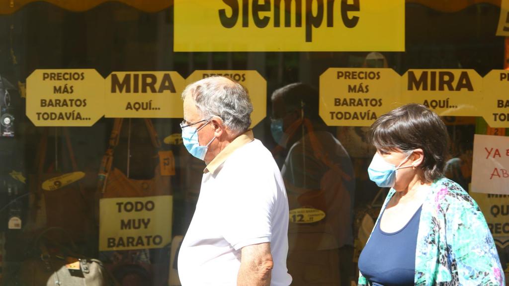 Dos personas pasan por delante de un comercio en Ponferrada