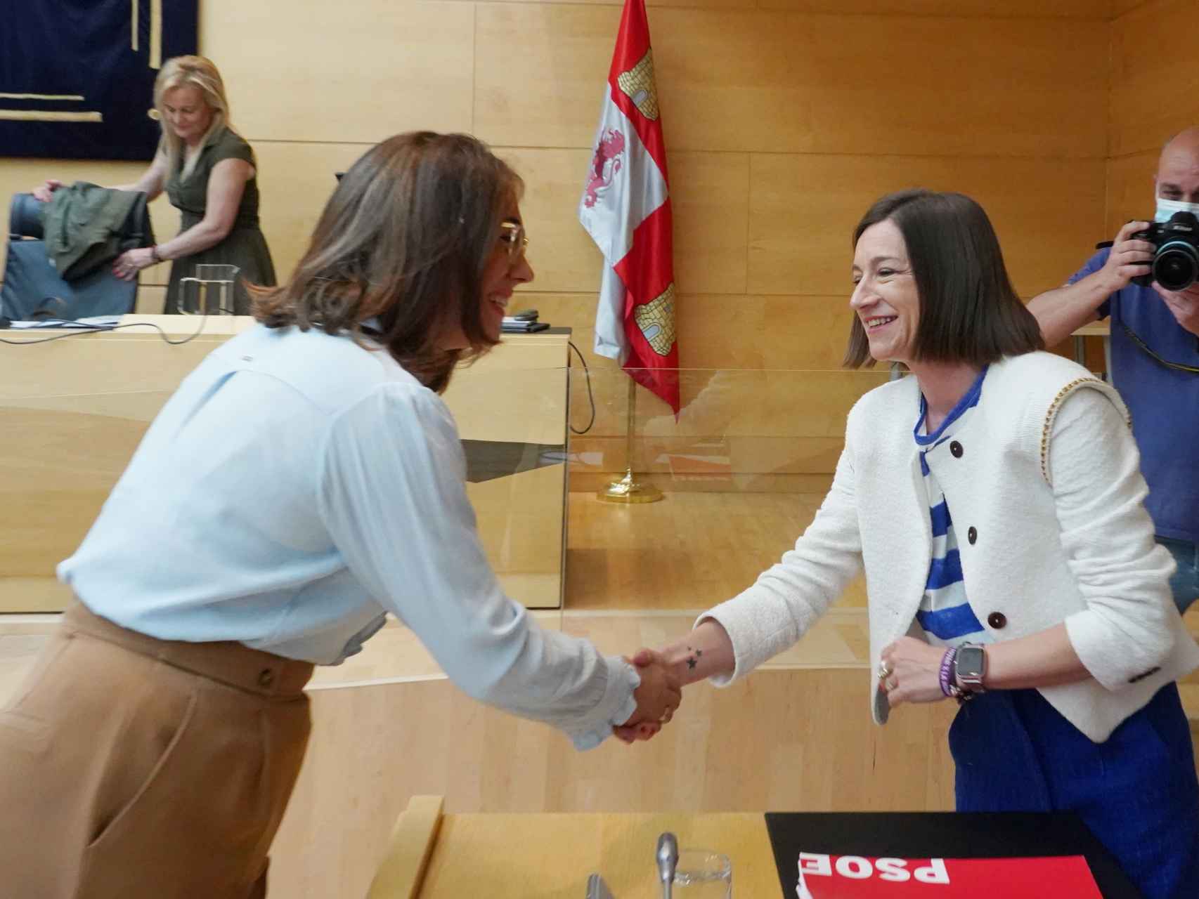 La consejera de Movilidad, María González, saluda a la procuradora socialista Laura Pelegrina, este miércoles en las Cortes.