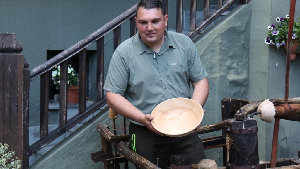 Trabau sostiene un cuenco elaborado por él mismo con madera natural