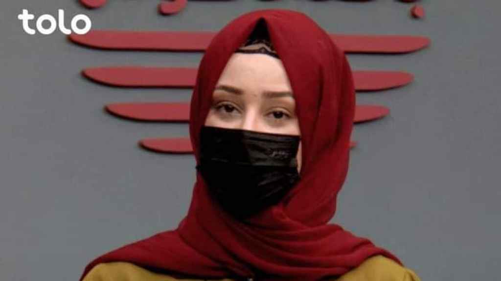 Una periodista del canal afgano Tolo cubra su cara con una mascarilla tras la orden de los talibanes.