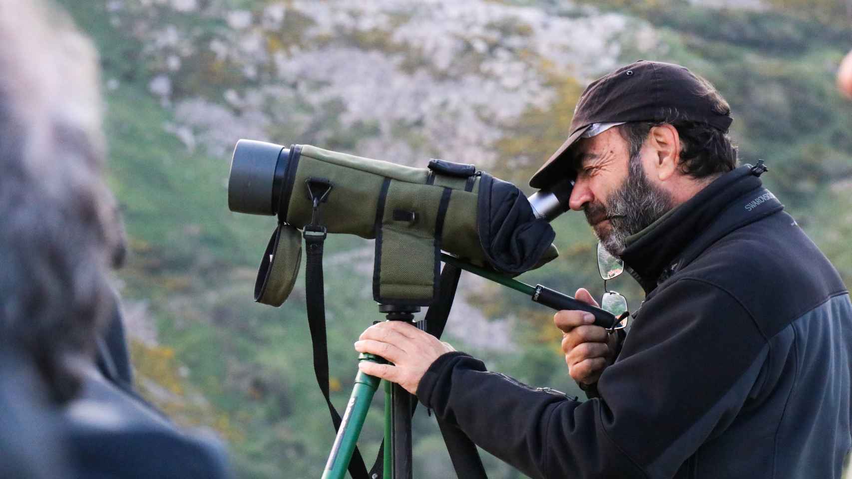 Juan Caros Blanco, de la Fundación Oso Pardo, mira por un telescopio durante una sesión de avistamiento de osos pardos