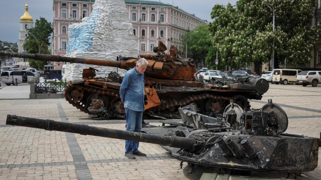 Un hombre observa un vehículo destruído de la infantería rusa en Kiev durante este sábado 21 de mayo