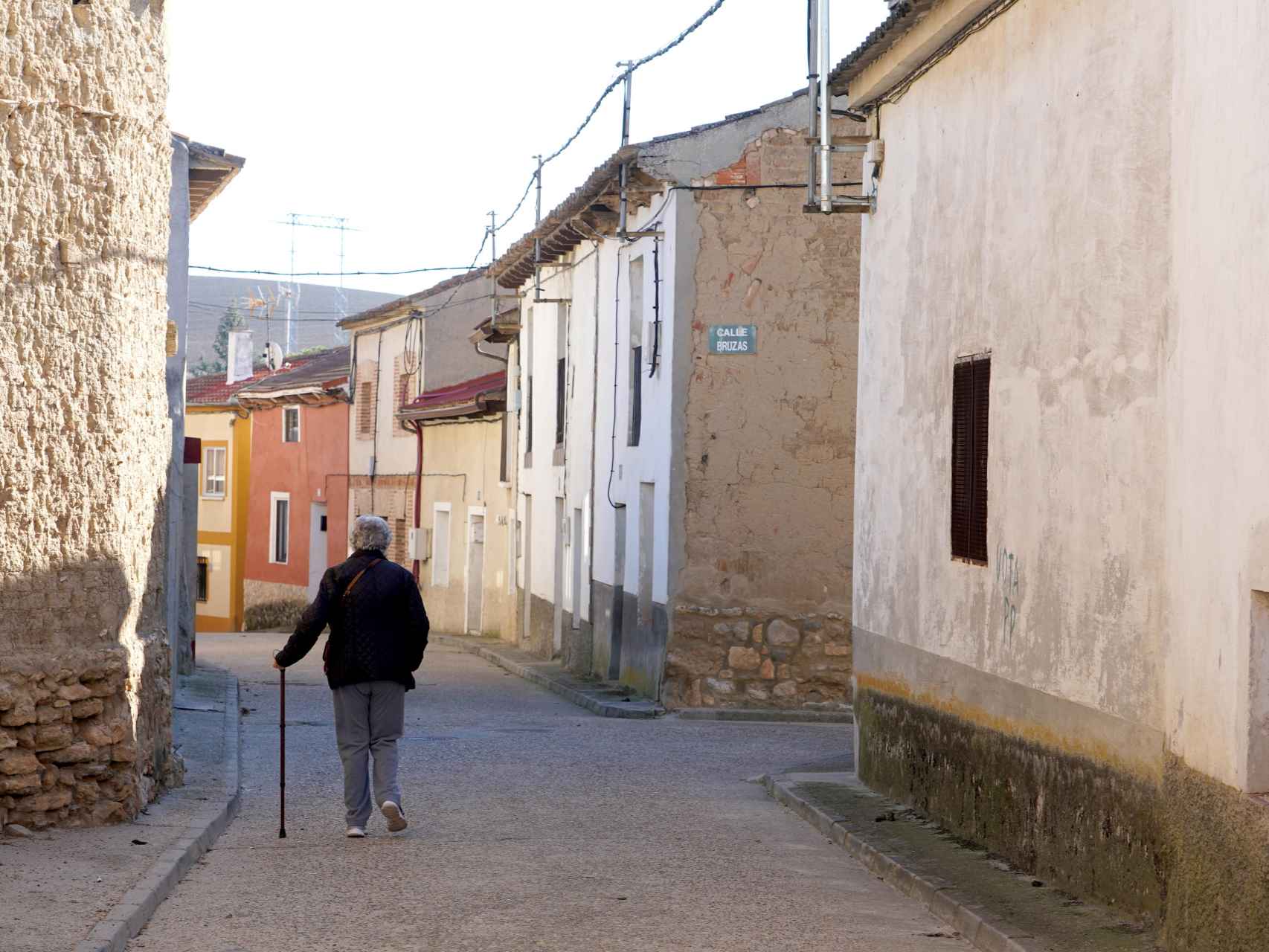 Una mujer camina por la calle de un pueblo de Valladolid.