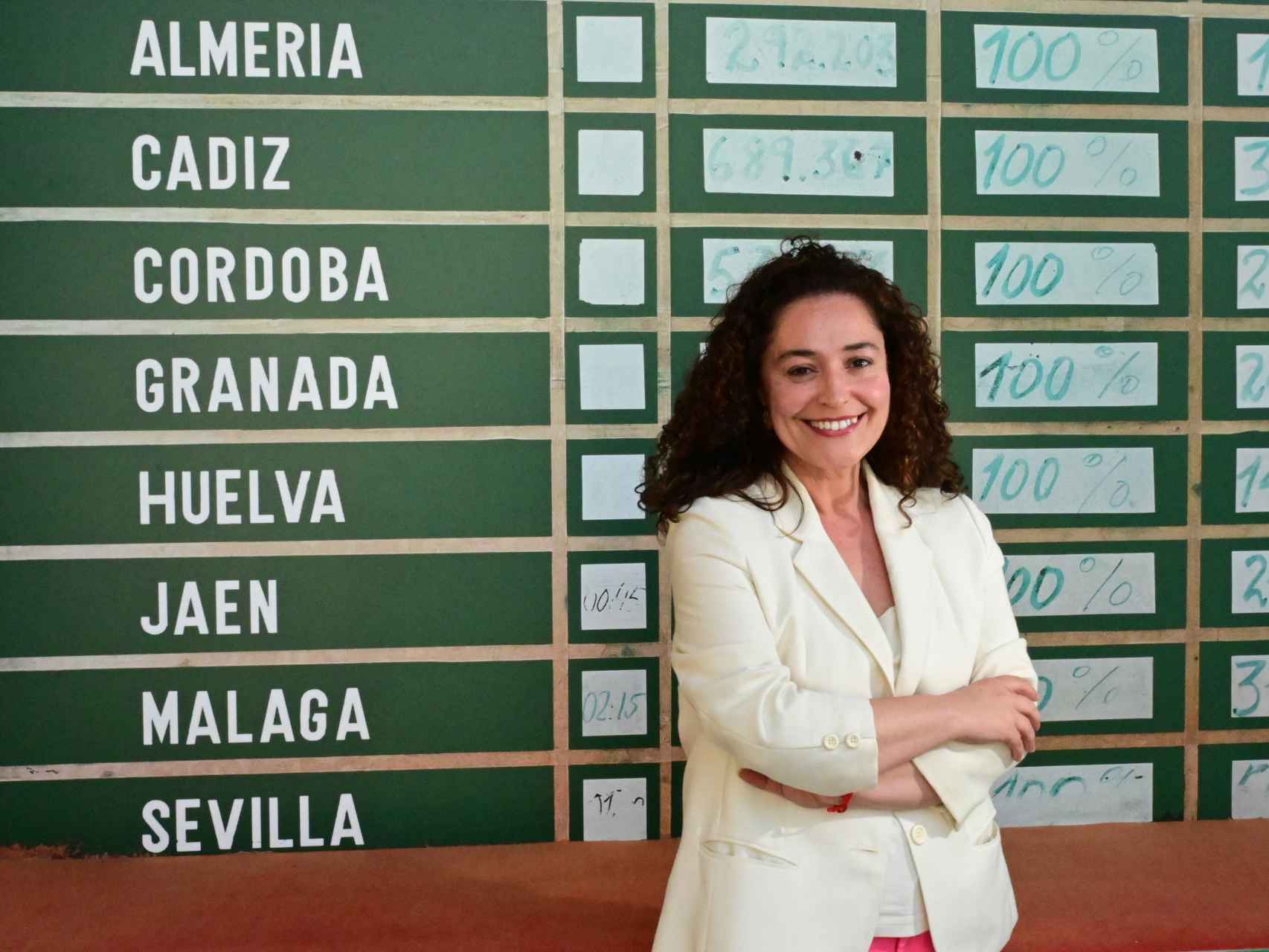 Inmaculada Nieto, junto a la enorme pizarra del Parlamento andaluz para los resultados electorales