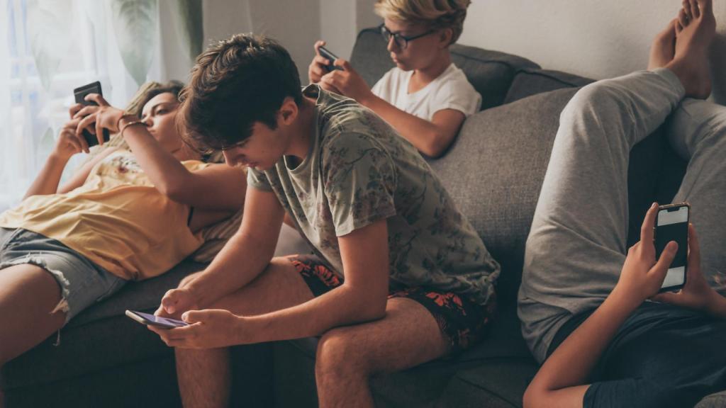 Un grupo de jóvenes con su teléfono móvil.