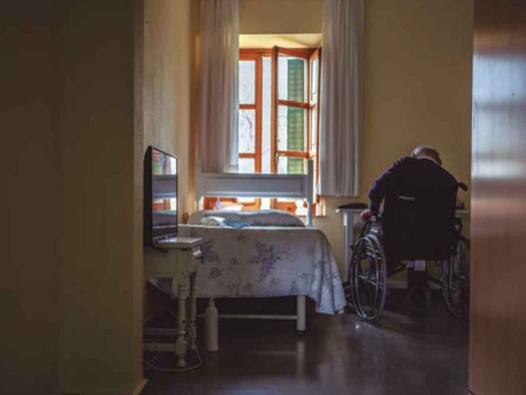 Un anciano espera en una residencia.