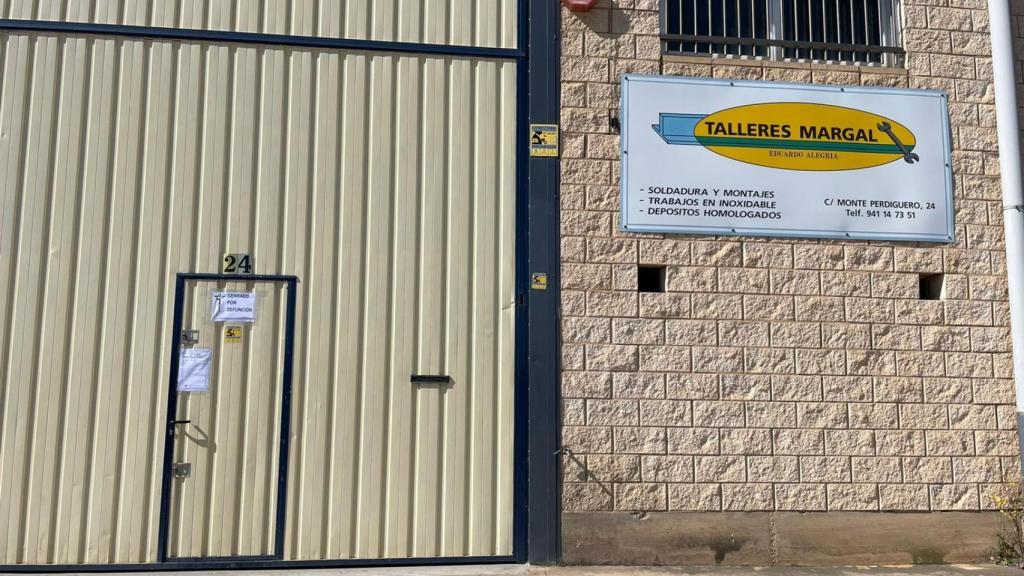 Entrada de la empresa familiar en la que trabajaban ambos operarios, cerrada con un anuncio de defunción.