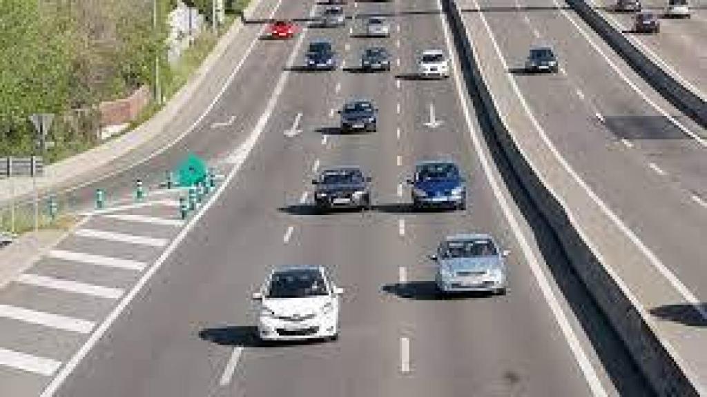 Varios coches circulando en la carretera.