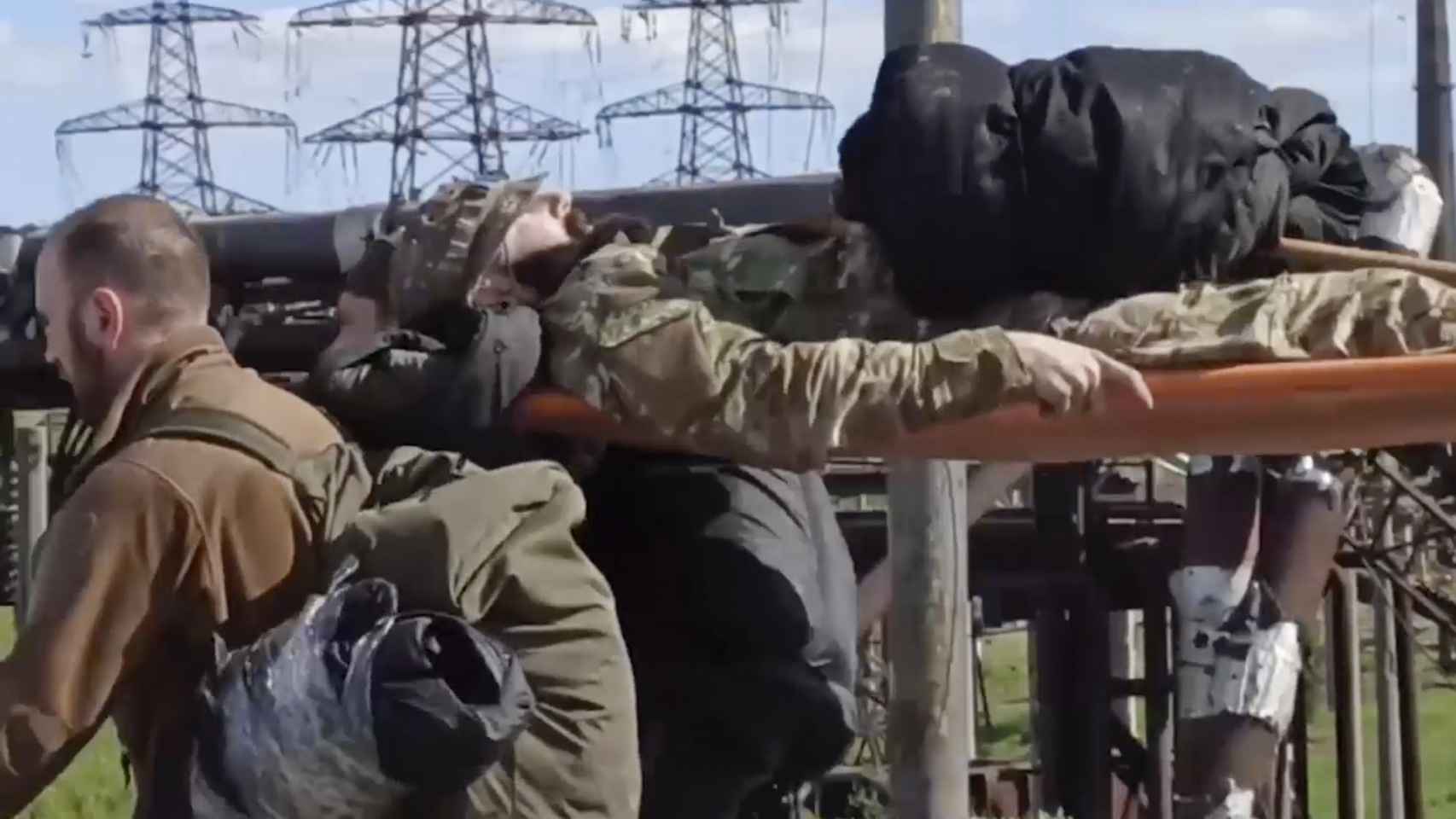 Soldados ucranianos llevan en una camilla a uno de sus compañeros heridos durante la evacuación de la  planta siderúrgica de Azovstal, en Mariúpol.