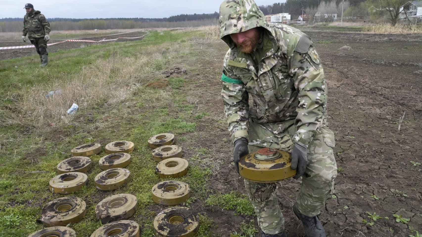 Un representante del Ministerio de Interior de Ucrania busca recoge minas de un campo minado después de las batallas en la ciudad de Irpin