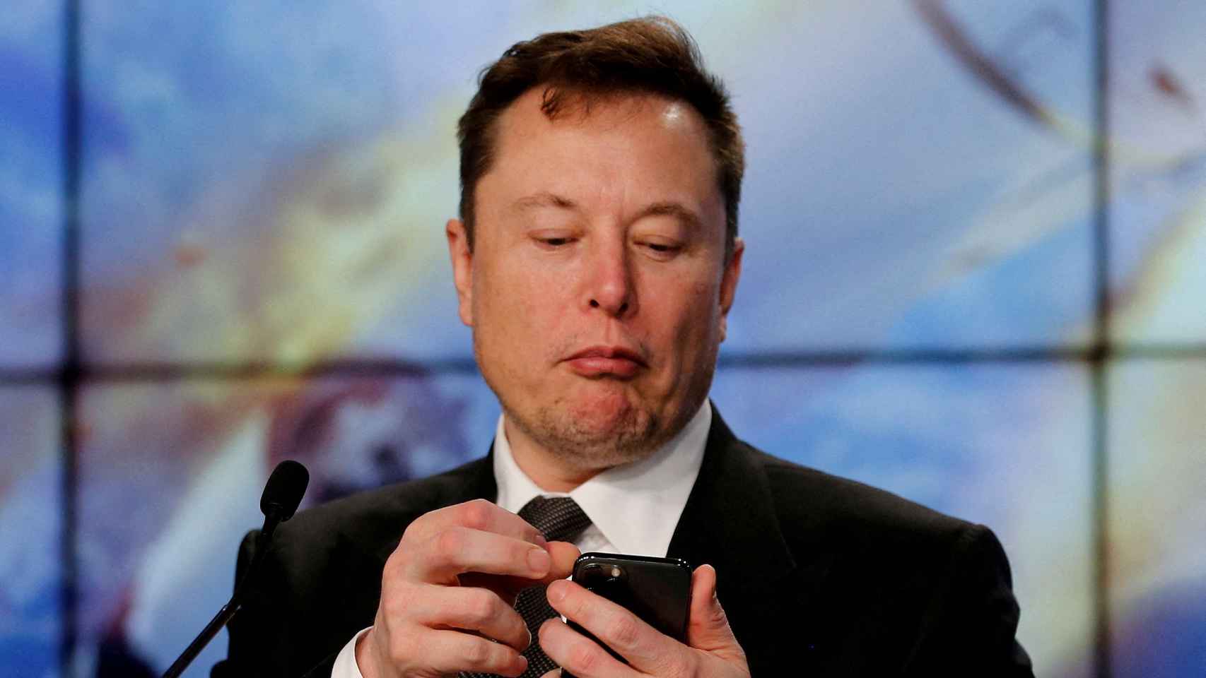 El empresario e inversor Elon Musk mirando su teléfono móvil.