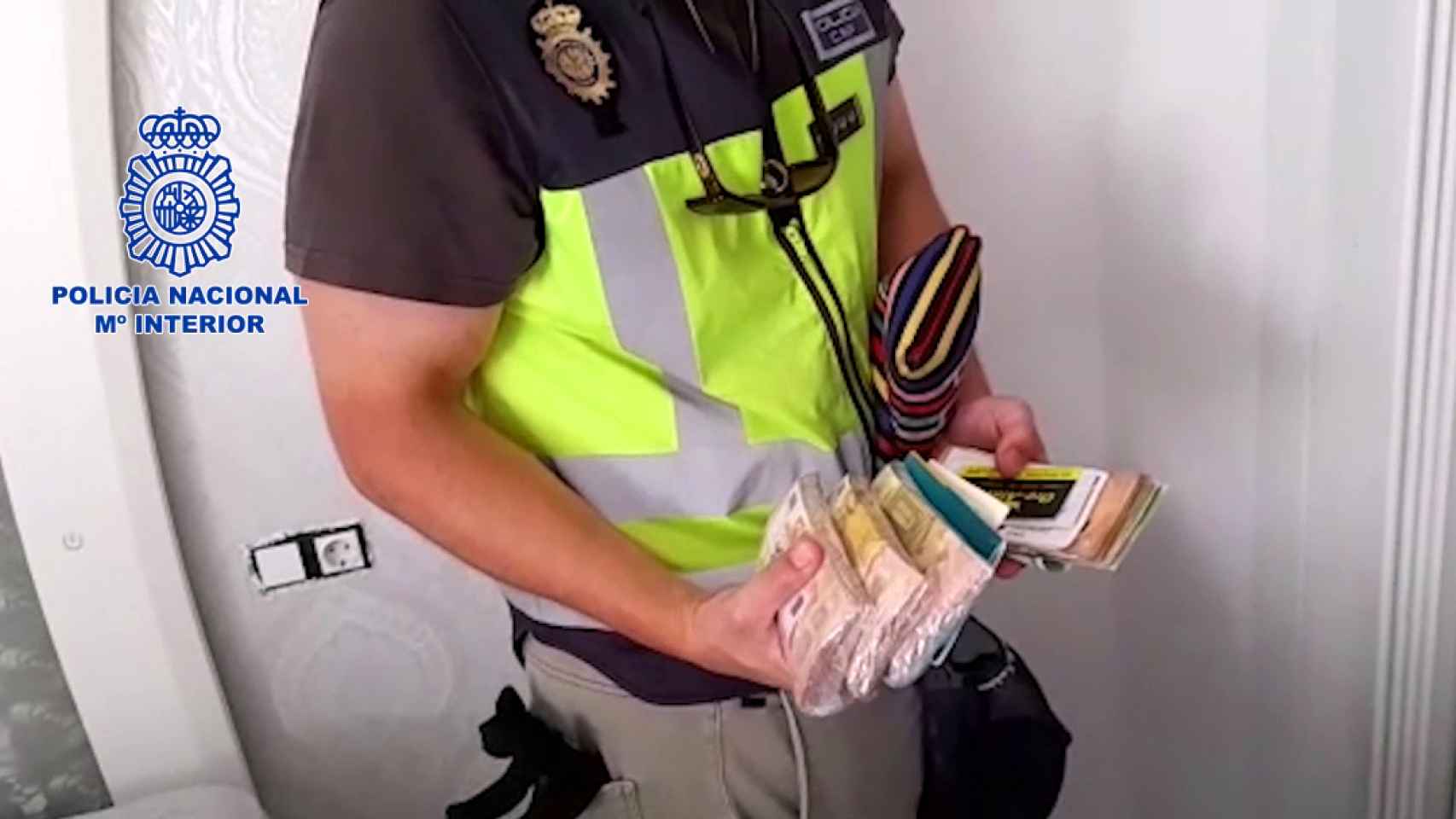 Un agente sostiene el dinero encontrado en la operación.