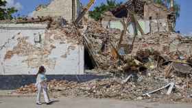 Dos niños pasan ante un edificio destruido en Járkov.