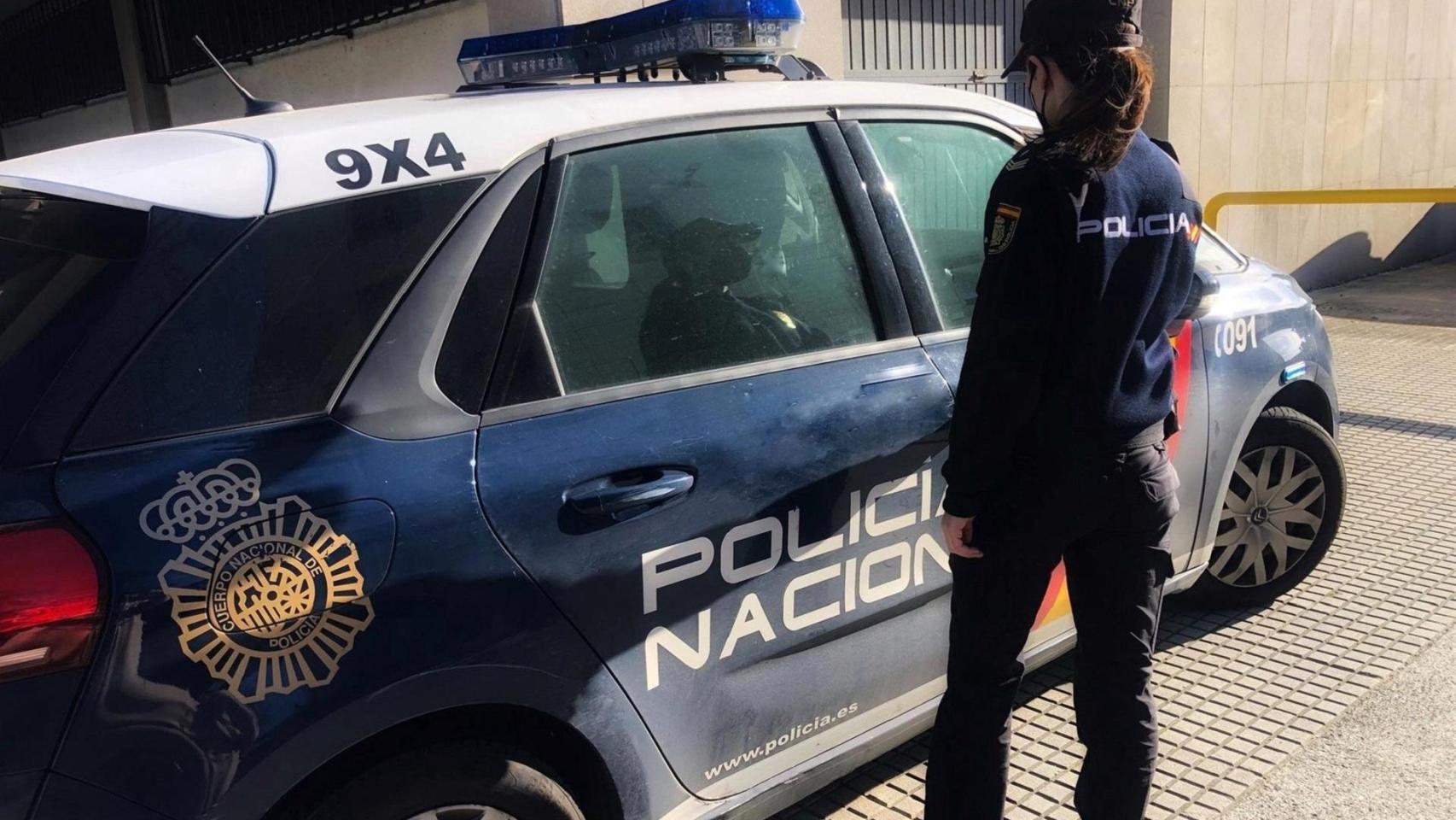 Imagen de archivo de una agente y un vehículo de la Policía Nacional.