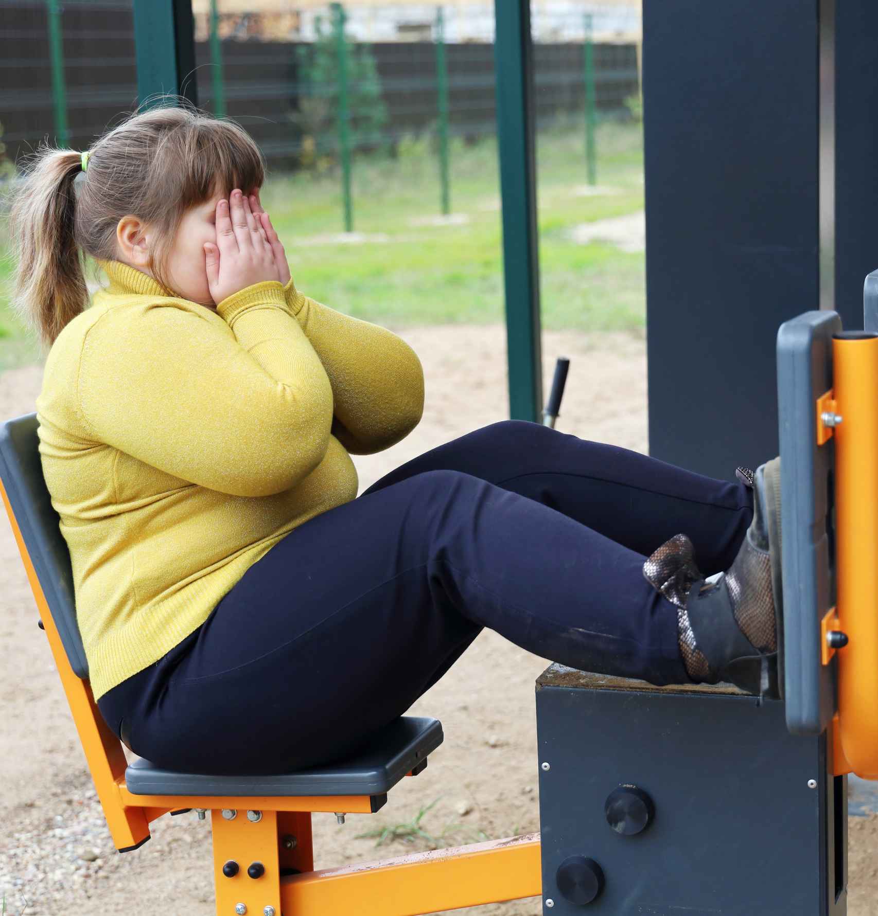Una niña con sobrepeso, haciendo ejercicio en el parque.
