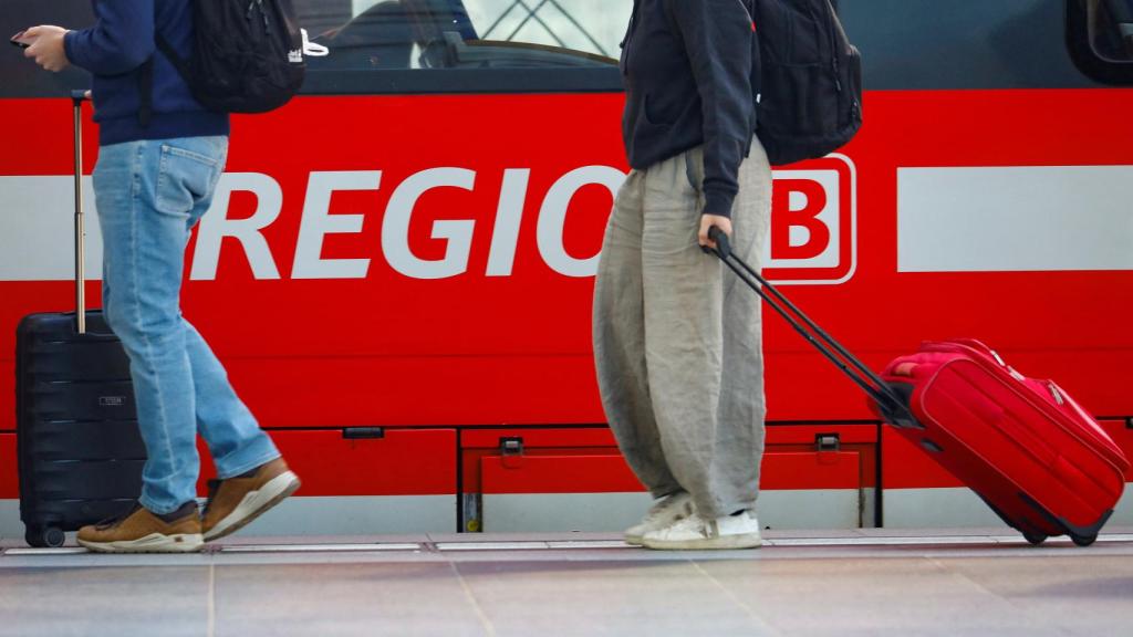 Un tren regional aleman y varios pasajeros esperando a entrar en él, en una imagen tomada en Berlín este 3 de junio