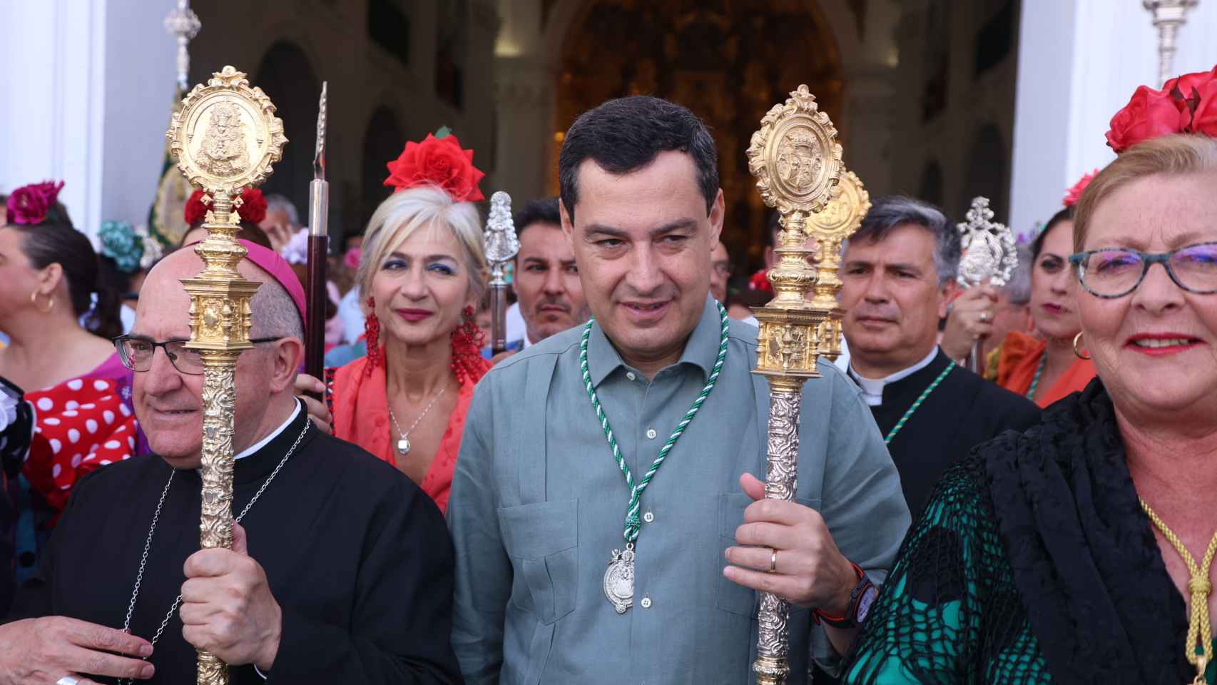 El presidente de la Junta, Juanma Moreno, en la ermita de la Virgen del Rocío, sostiene la vara de hermano mayor de la Hermandad.
