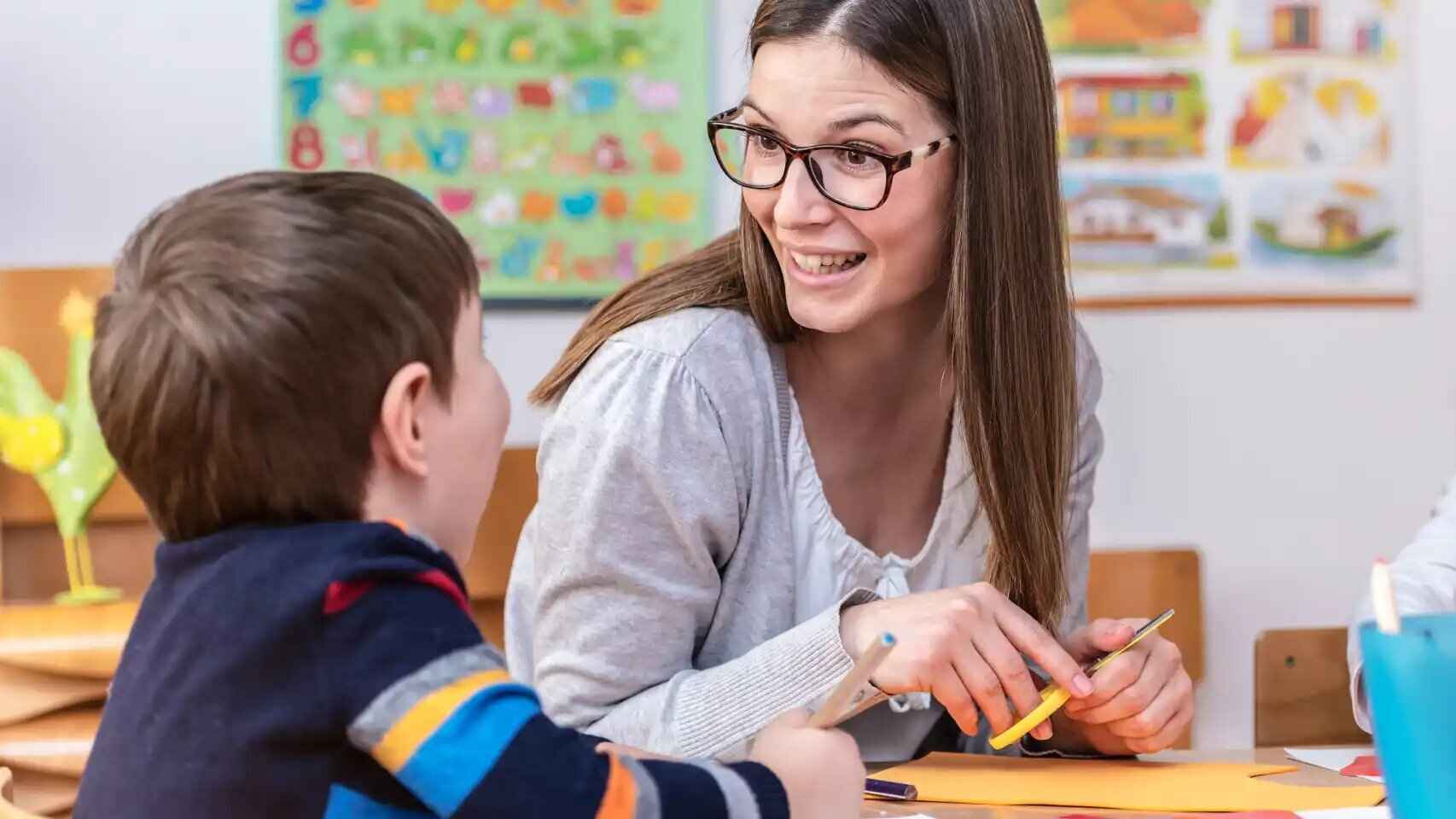 Una profesora con su alumno en clase.