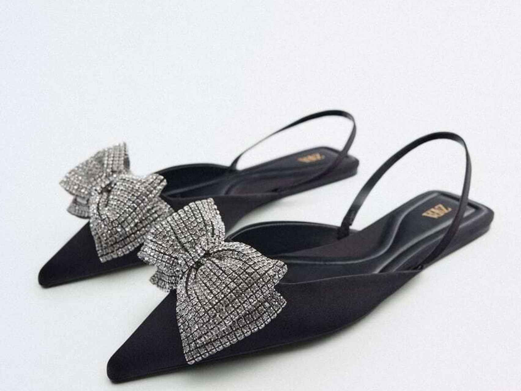 Zapato plano en color negro y lazado brillante, de Zara.