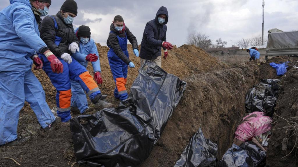 Los cadáveres se colocan en una fosa común en las afueras de Mariúpol, Ucrania, en marzos.