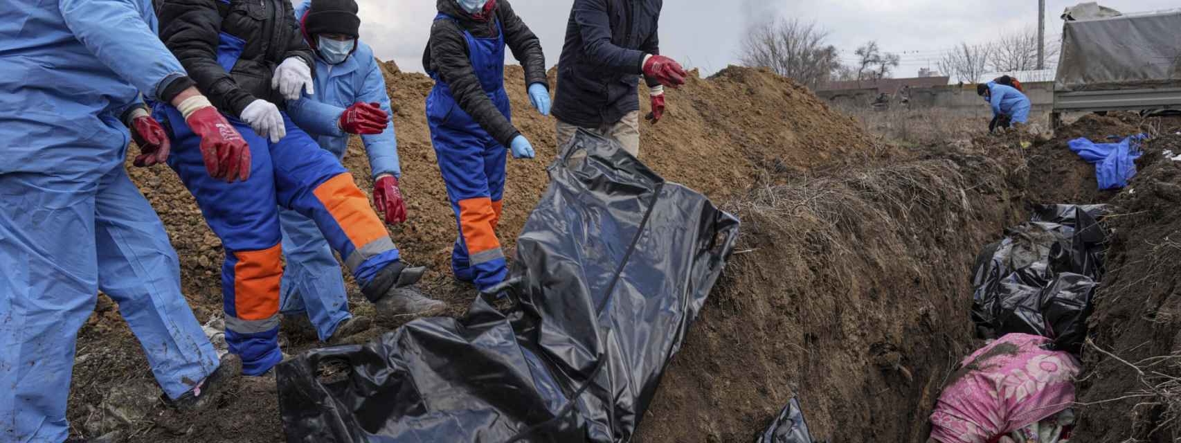 Los cadáveres se colocan en una fosa común en las afueras de Mariúpol, Ucrania, en marzos.