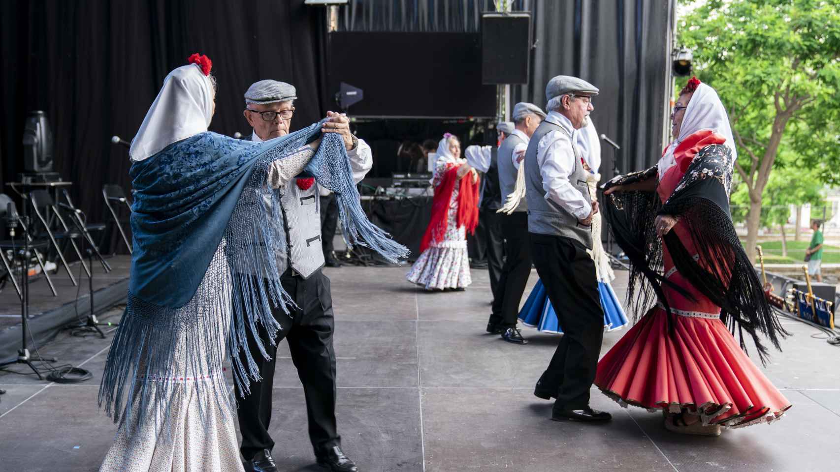 Varias parejas, vestidos de chulapa y chulapo, bailan un chotis, en un acto de la Federación Grupos Tradicionales madrileños en las fiestas de San Isidro, a 14 de mayo de 2022, en Madrid (España).