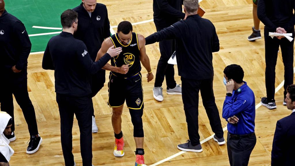 Stephen Curry sale de la pista tras lesionarse.