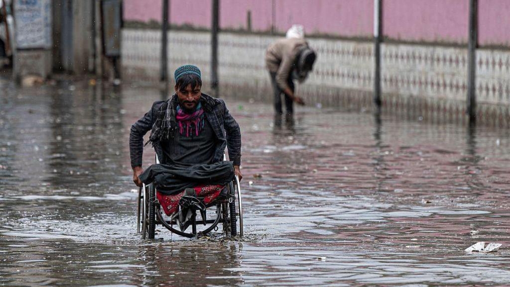 Una persona en silla de ruedas durante las inundaciones de mayo en Afganistán.