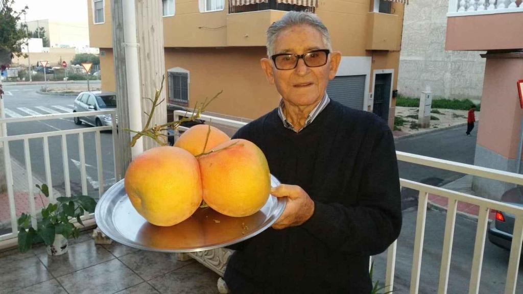 El difunto Pedro Pérez mostrando algunos de los frutos que cosechaba en su huerto.