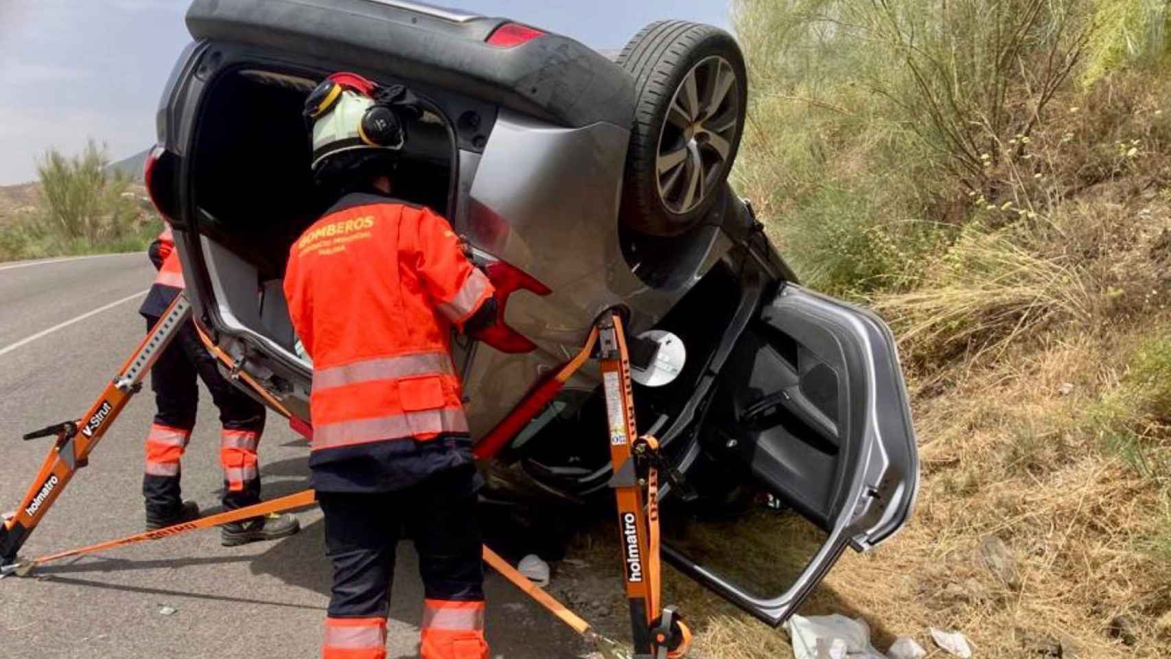 Efectivos del Consorcio Provincial de Bomberos de la Diputación excarcelan a una persona atrapada en el interior de un vehículo accidentado en La Viñuela.