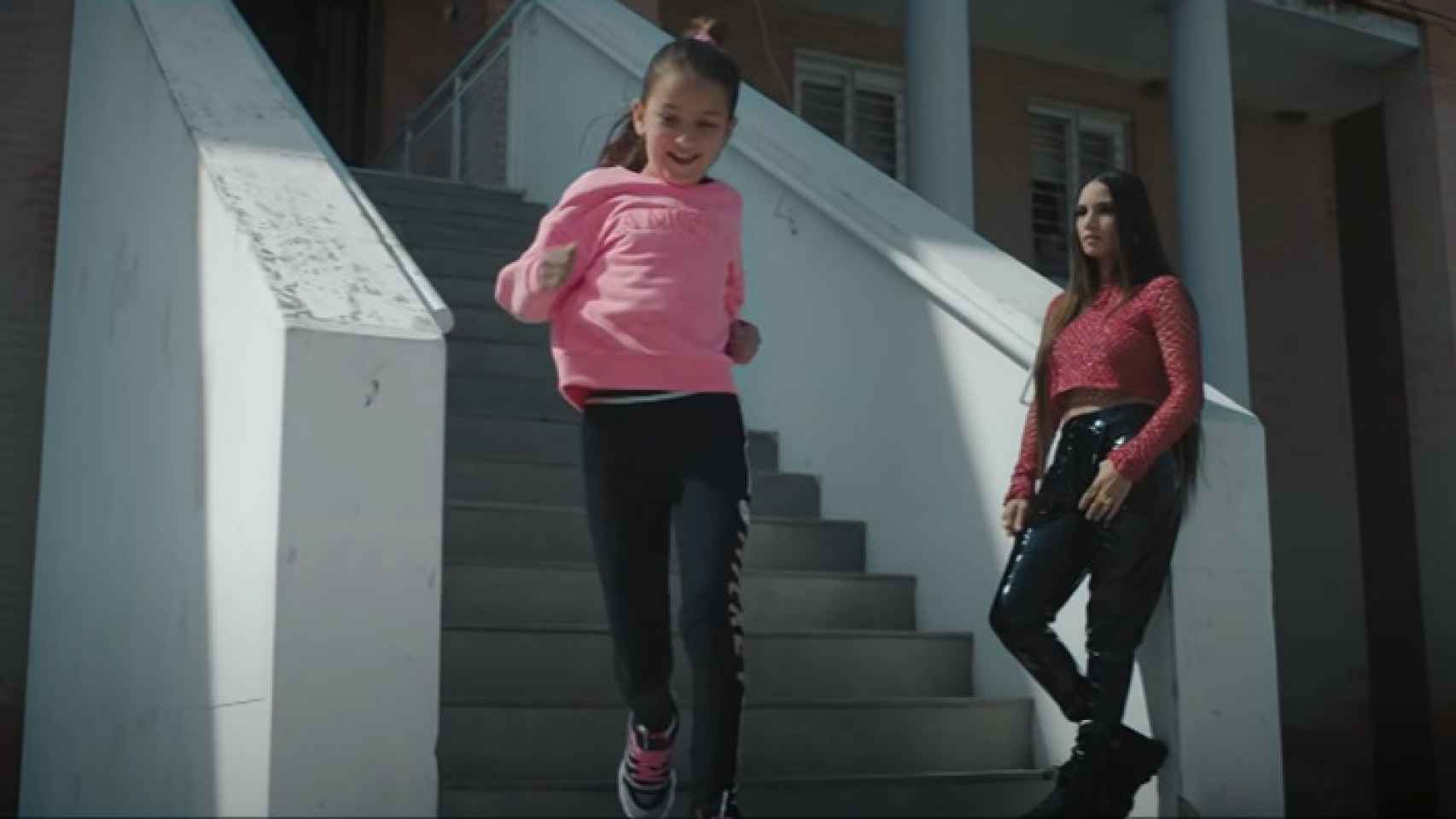 India en su portal junto a una niña en el videoclip de La Gitana.