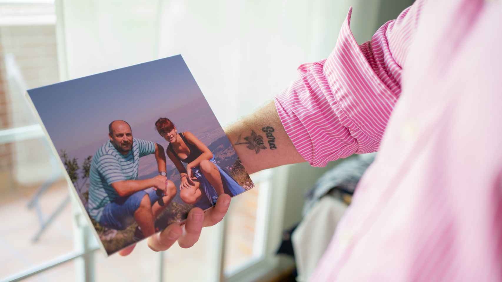 Francisco muestra una foto de su mujer y un tatuaje con el nombre de su hija.