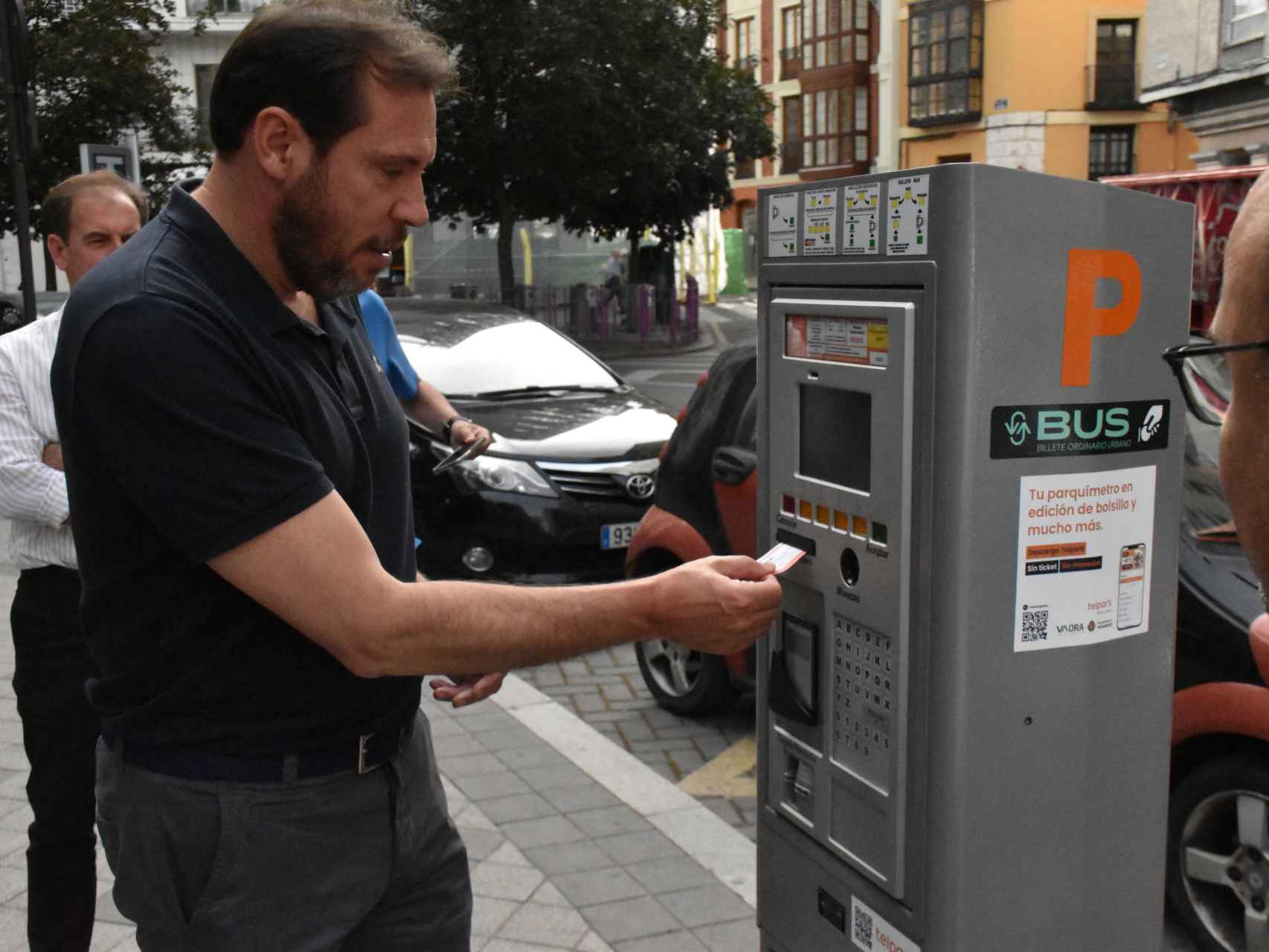 Óscar Puente saca un billete de bus ordinario en un parquímetro de Valladolid.