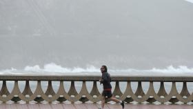 Un hombre, con chubasquero, corre por el Paseo Marítimo de A Coruña en una foto de archivo.