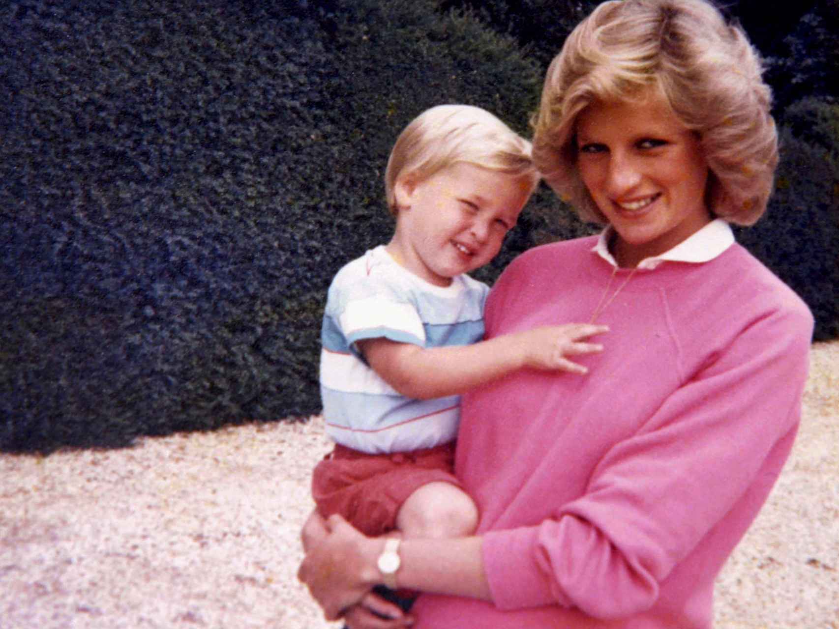 La princesa Diana de Gales sostiene en brazos a su hijo Guillermo mientras está embarazada del príncipe Harry.