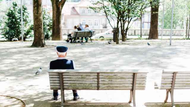Un anciano solo en el banco de un parque