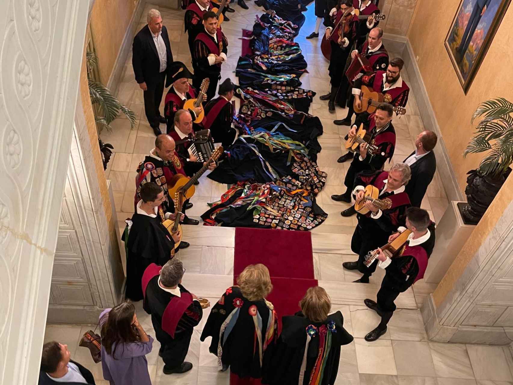 La tuna recibe a las reinas en las escaleras del Ayuntamiento