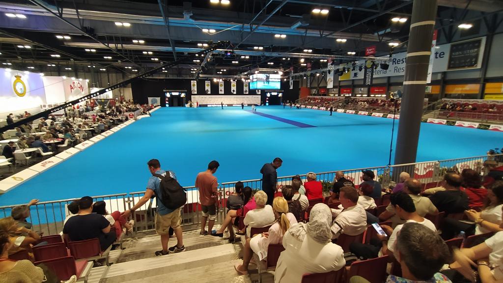 Un grupos de perros, con sus dueños, desfilando en el ring central ante la mirada del público.