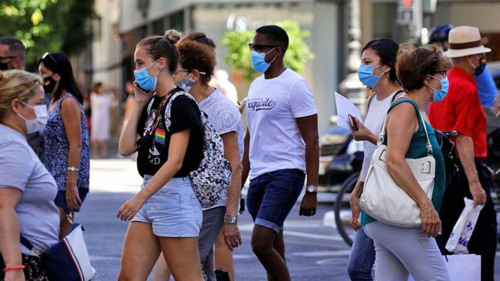 Gente con mascarilla andando por la calle.